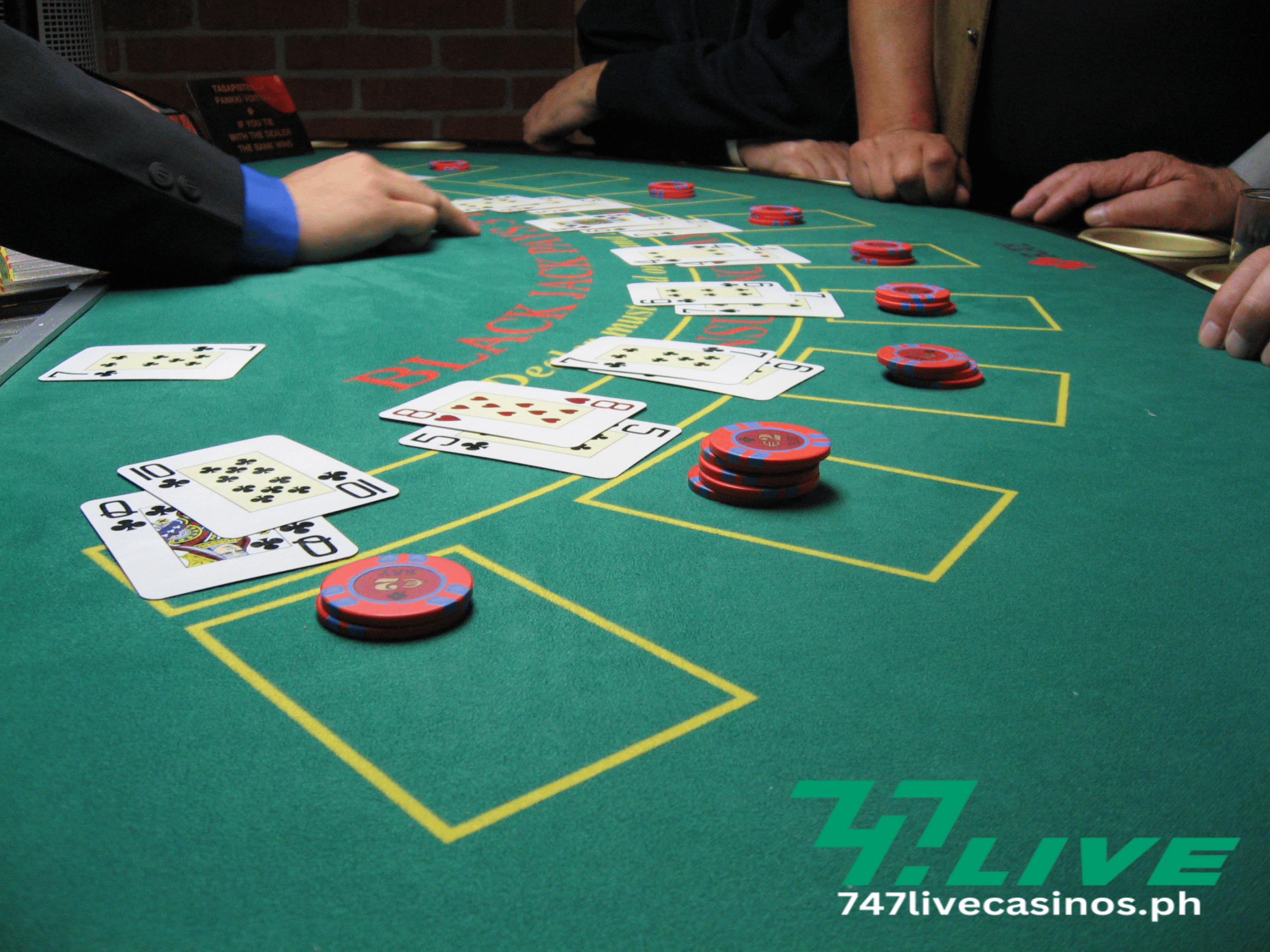 a blackjack table with players playing and cards are already on the deck together with their bets